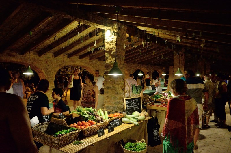 Foto del puesto de uno de nuestros productores con frutas y verduras en un mercado de verano nocturno