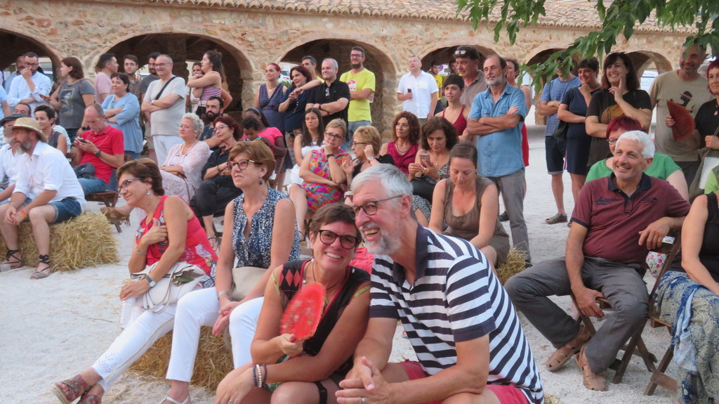 Foto de la gente sentada en el Mercat del riurau disfrutando del evento